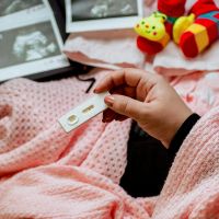 Hand holding a positive pregnancy test